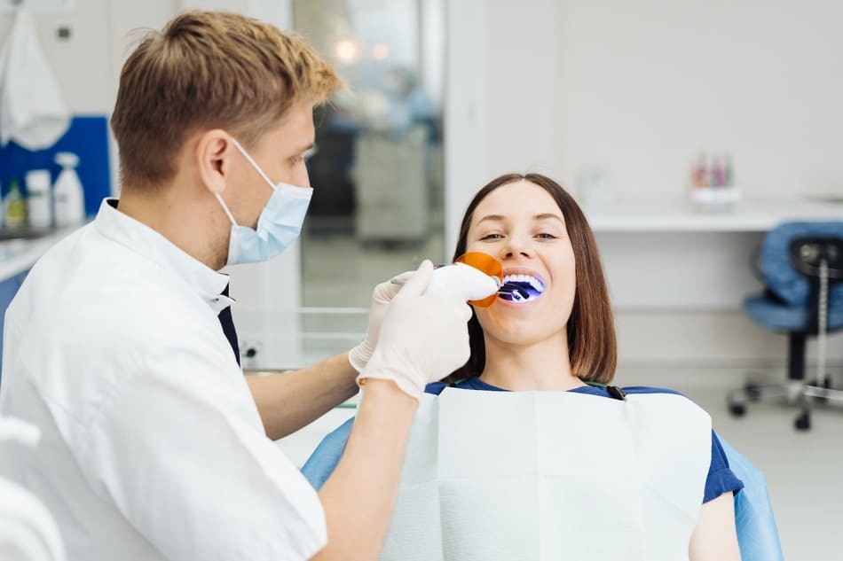 dentista haciendo blanqueamiento dental
